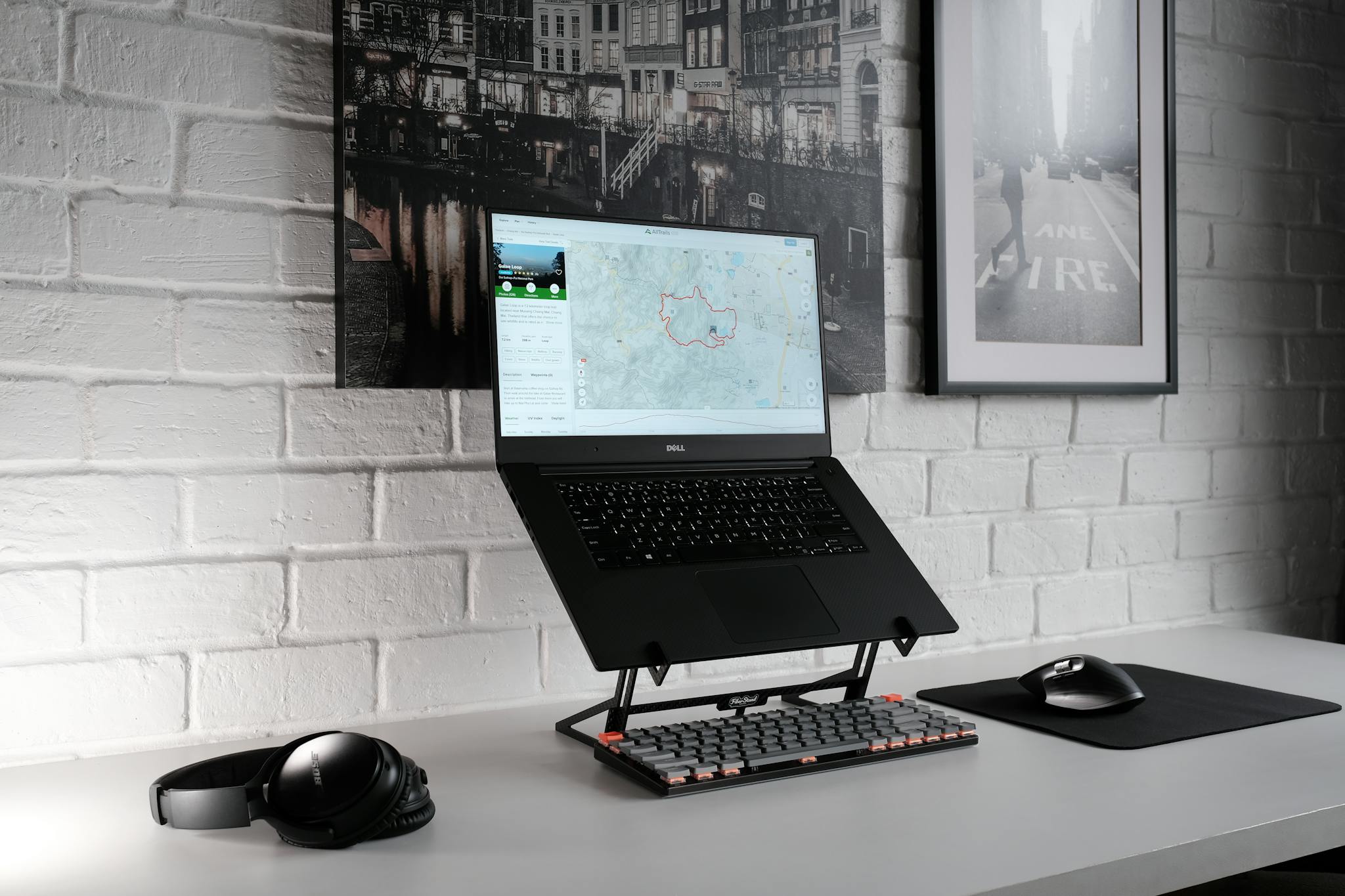 A stylish workspace featuring a laptop, headphones, and a sleek keyboard on a desk.